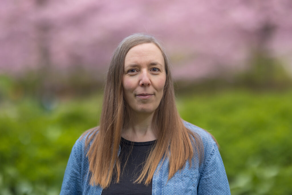 Åsa Callmer porträtt mot bakgrund av blommande träd