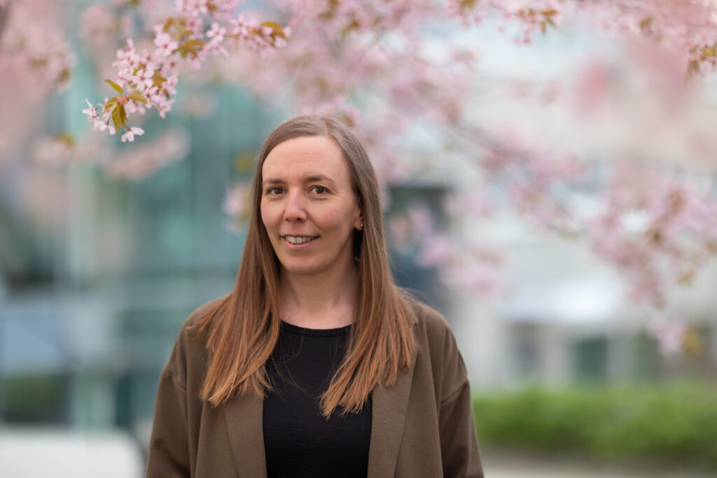 porträtt av Åsa Callmer med körsbärsblom i bakgrunden